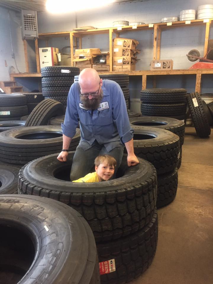 Photo of father and son playing in tire wheels.
