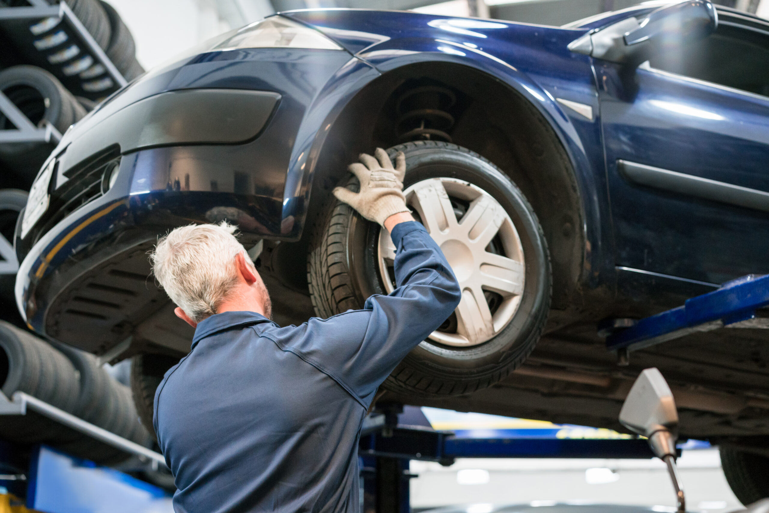 Car mechanic checking car wheel.